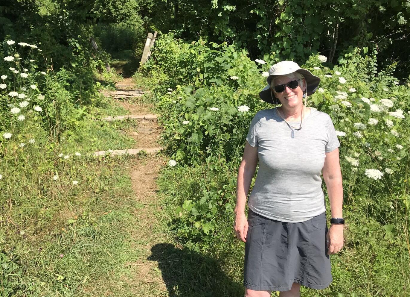 A woman smiles on a hiking trial
